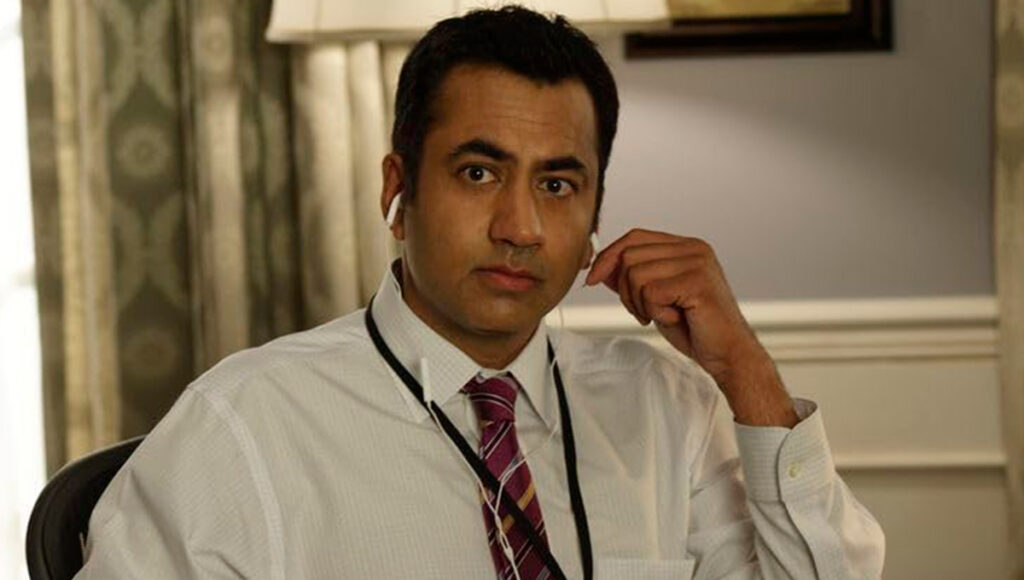 Kal Penn com fones de ouvido em um quarto