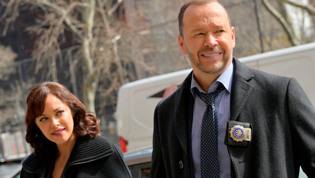 Os personagens Danny Reagan e Maria Baez caminhando soridentes em Blue Bloods